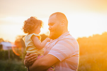 Daddy holding little baby in hands at a golden hour 