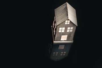 Energy saving concept: A lighted miniature house symbolizes the usage of light in a building or...