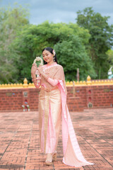 Beautiful asian woman with Thai traditional costume holding garland