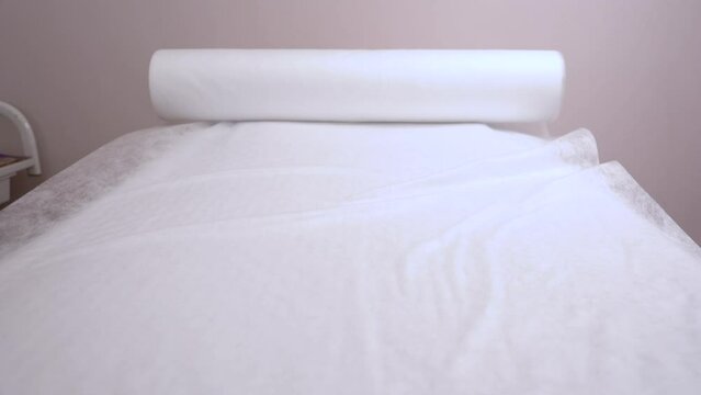 Rolled white towel on massage table in empty spa salon. Massage table.