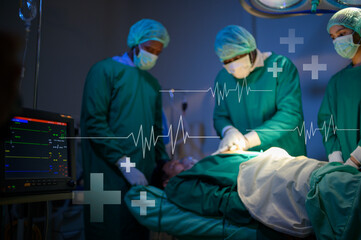 Professional doctors in the operating room making  CPR and use defibrillator electrical device to...