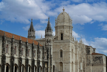 Fototapeta na wymiar Ancient walls and towers of the Jeronimos Monastery (Mosteiro dos Jerónimos) in Lisbon, Portugal, Europe. Portuguese Gothic Manueline style of architecture. Exterior of the main church and cloister.