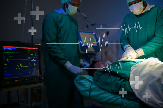 Professional doctors in the operating room making  CPR and use defibrillator electrical device to saving a patient life. health care concept.