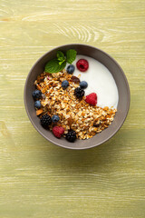 Overhead view of healthy grain granola with berry yoghurt top view on wooden surface