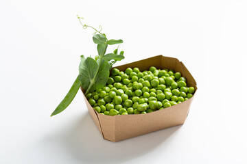 Close up of fresh sweet green peas seeds in paper container food delivery concept