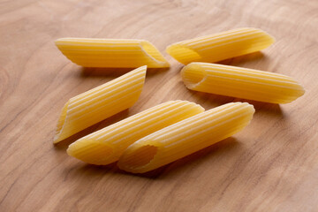 small compositions of durum wheat pasta with wooden background