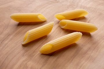 small compositions of durum wheat pasta with wooden background
