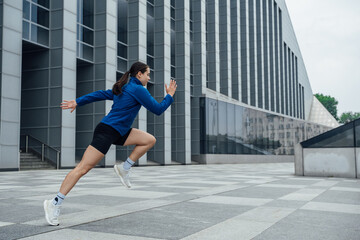 Fototapeta na wymiar Shot of sportswoman jogger dressed in sportswear working out outdoors in city.