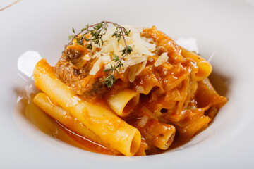Piatto di pasta con sugo di genovese napoletana fatta con carne e cipolla e scaglie di parmigiano servito in un ristorante 