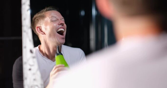 Emotionally joyful happy handsome man sings in bath in hair dryer