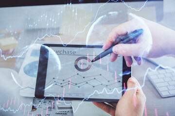 Double exposure of man's hands holding and using a phone and financial chart drawing. Market analysis concept.
