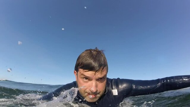 SLOW MOTION, CLOSE UP: Extreme sportsman having fun riding a beautiful barrel ocean wave. Breathtaking shot of active man on holiday surfing a perfect crystal wave in afife, Viana do Castelo