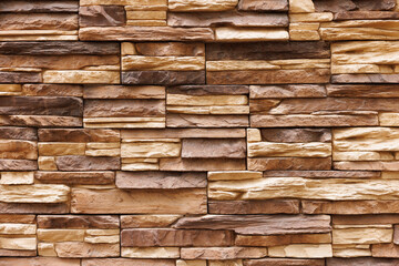 Brick wall cladding with narrow natural stones of various sizes and shapes.