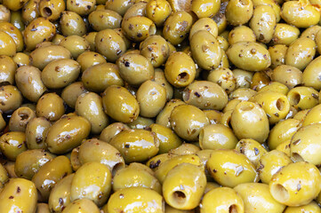 Marinated pitted olives with spices as background