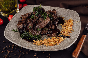 Beef liver with onions chips on plate