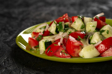 close-up shot of salad with tomatoes and cucumbers on black