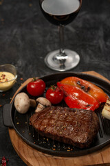 grilled beef steaks with tomato sauce on black stone background