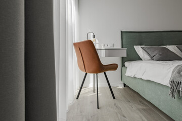 Modern minimalistic bedroom interior design in grey shades with light green bed, eucalyptus in glass vase. Scandinavian style.  Aesthetic simple interior design concept.