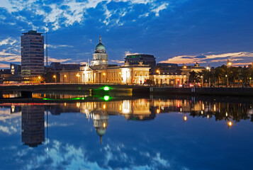 Dome of the Customs house reflected in the River Liffey illuminated at dusk