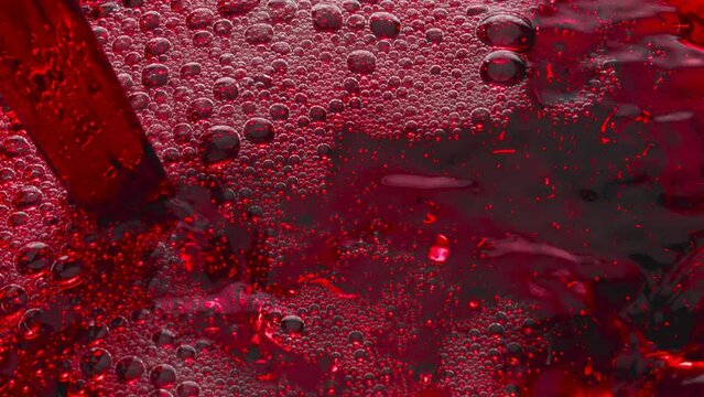 Bubbled red wine pouring glass slow motion. Alcoholic liquor filling wineglass