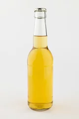Gordijnen Image of clear glass full lager beer bottle with crown cap, with copy space on white background © vectorfusionart