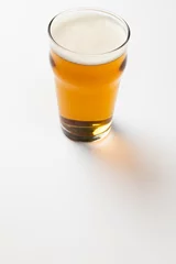 Gordijnen Image of full pint glass of lager beer, with copy space on white background © vectorfusionart