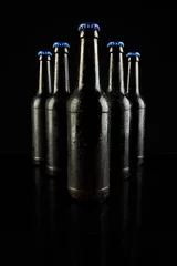 Gordijnen Image of five beer bottles with blue crown caps, with copy space on black background © vectorfusionart
