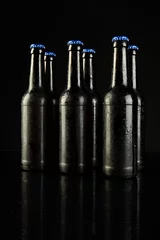 Gordijnen Image of six beer bottles with blue crown caps, with copy space on black background © vectorfusionart