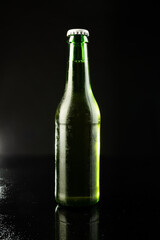 Image of green glass beer bottle with white crown cap, with copy space on black background