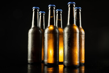 Image of six beer bottles with blue crown caps, with copy space on black background