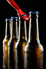Foto op Canvas Image of red bottle opener and four beer bottles with blue crown caps, with copy space on black © vectorfusionart