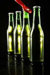 Foto op Canvas Image of red bottle opener and four green beer bottles with crown caps, with copy space on black © vectorfusionart