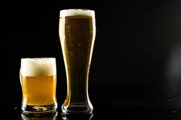 Foto op Canvas Image of full pint glass and tankard of foamy beer, with copy space on black background © vectorfusionart