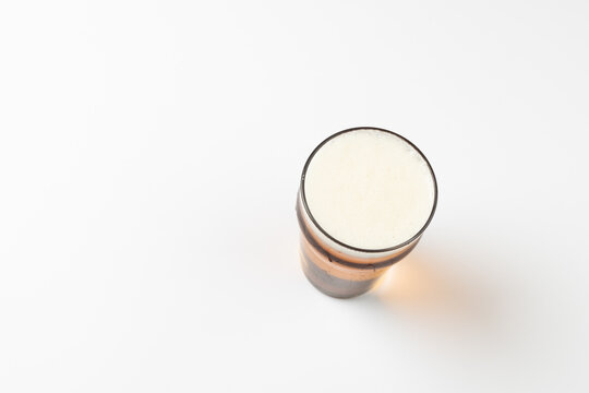 Overhead Image Of Full Pint Glass Of Lager Beer, With Copy Space On White Background