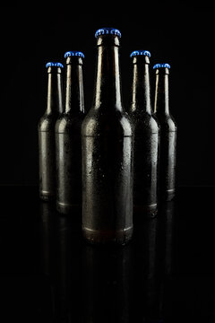 Image of five beer bottles with blue crown caps, with copy space on black background