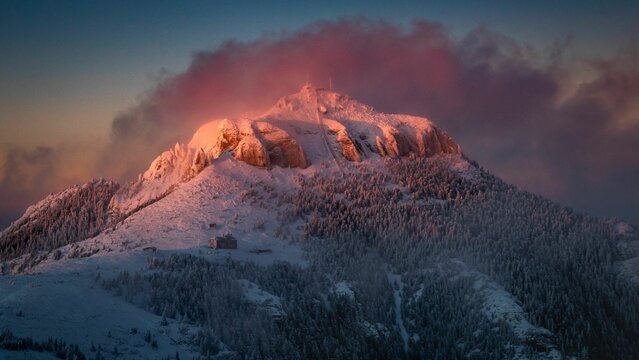 Scenic view of the snowy Toaca peak in Ceahlau Mountain against dusk sky, Romania