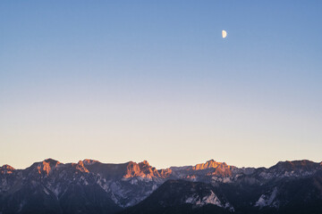 coucher de soleil et demi lune sur les Alpes