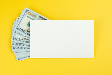 Envelope with a stack of one hundred dollar bills on a yellow background. The concept of money as a gift, bribe, cash storage. Template for design, space to insert text.