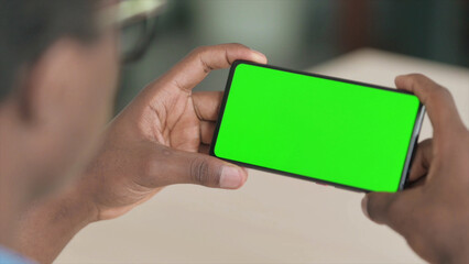 Close Up of Young African Man Watching Smartphone with Chroma Screen