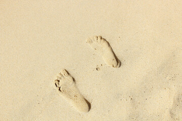 Fototapeta na wymiar Two footprints on yellow sand