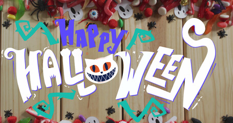 Image of halloween text over decorations and sweets on wooden background