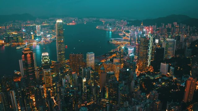 Drone shot of the bay of Hong Kong nearly at night showing the extent of the wealth of the city and the boat traffic.