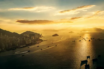 Poster Hong Kong Harbor at sunset with many ships in the sea silhouette © Rattanapon