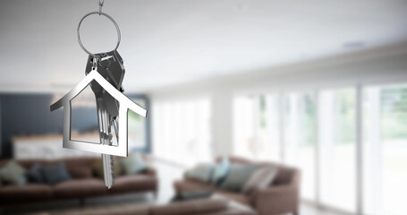 Image of silver key and house over empty house interior