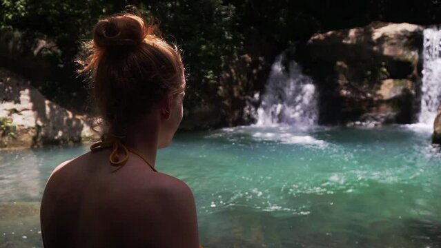 young attractive caucasian woman standing in front of scenic waterfall landscape in tropical rainforest Costa Rica central america travel holiday destination in Las Chorreras, Liberia,