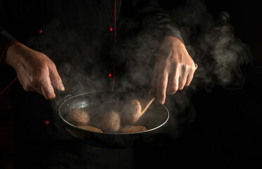 Cooking beef or pork cutlets in a hot pan with steam in the hands of the cook. Menu or recipe for...