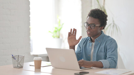 Young African Man Talking on Video Call on Laptop in Office