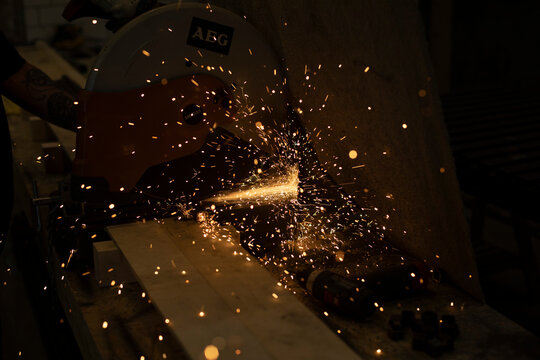 Sparks from sawing metal. Lights in dark.