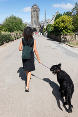 Woman walking along the avenue with her dog