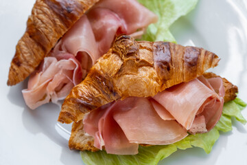 Croissants sandwiches with prosciutto (jamon, cured ham, prosciutto crudo) and lettuce. Delicious...